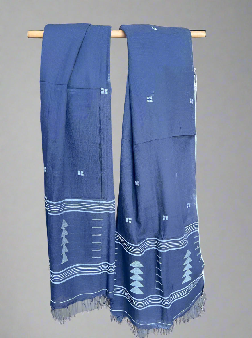 Black scarf with white patterns on a wooden rod against a gray background