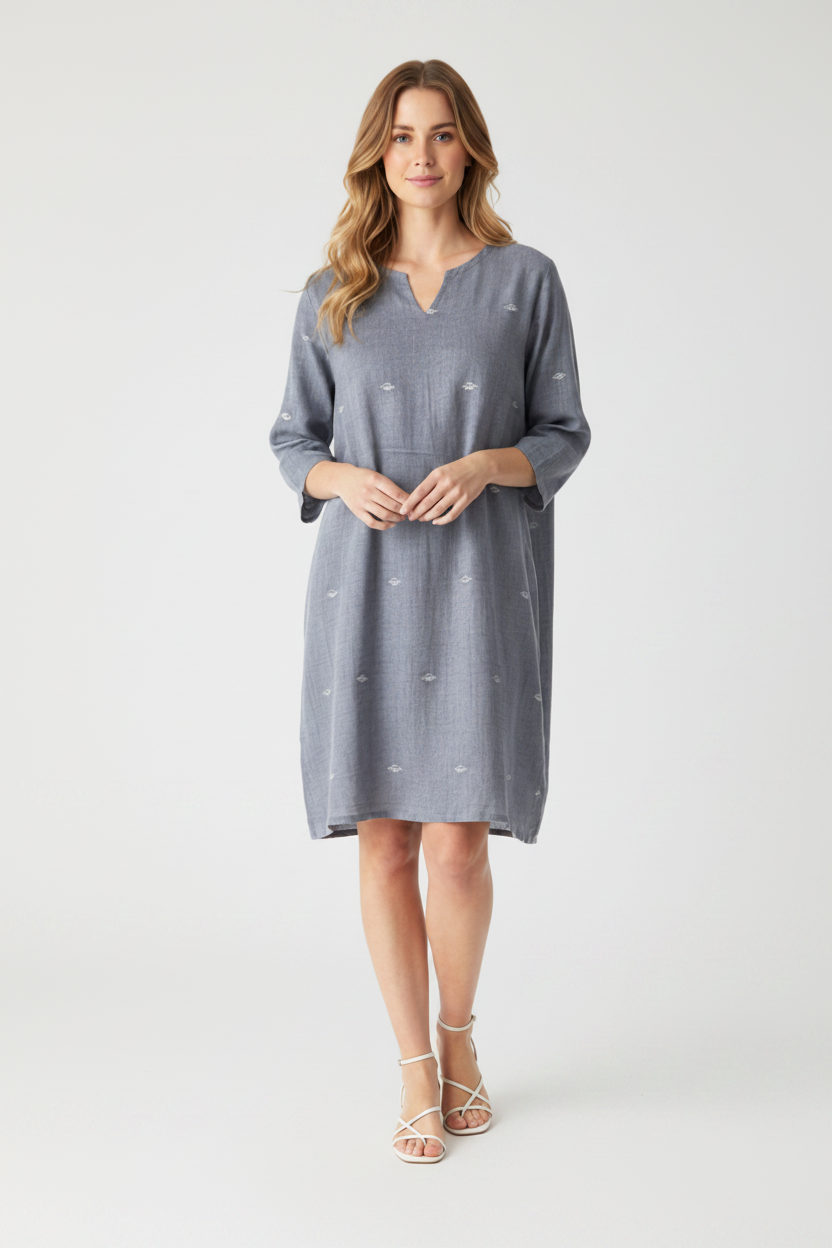Woman wearing a gray dress with white polka dots on a white background