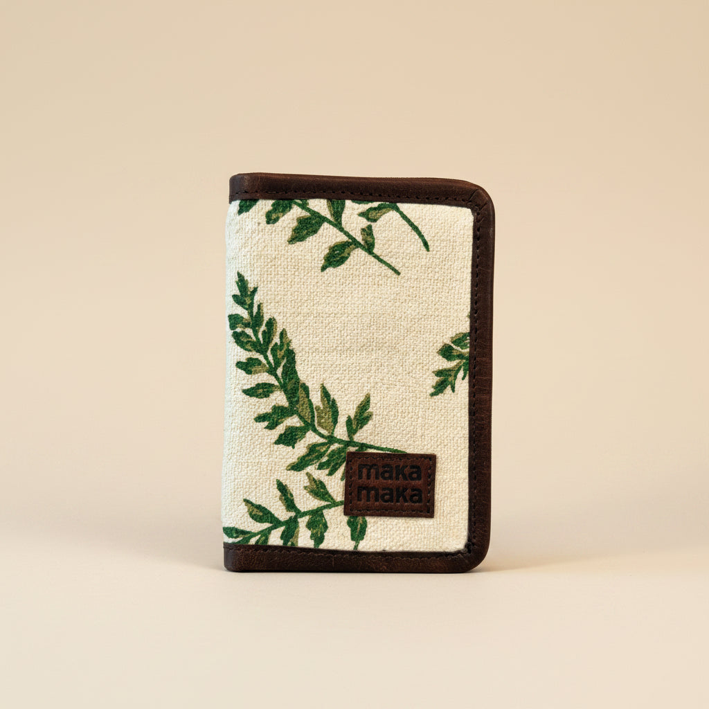 A Botanical - block printed passport holder burlap-canvas with leather trim - open green leaf block printed, dark brown trim, and a embossed 'maka maka' logo 