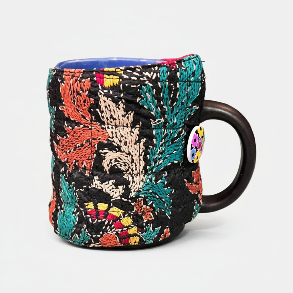Colorful embroidered coffee cozy on mug