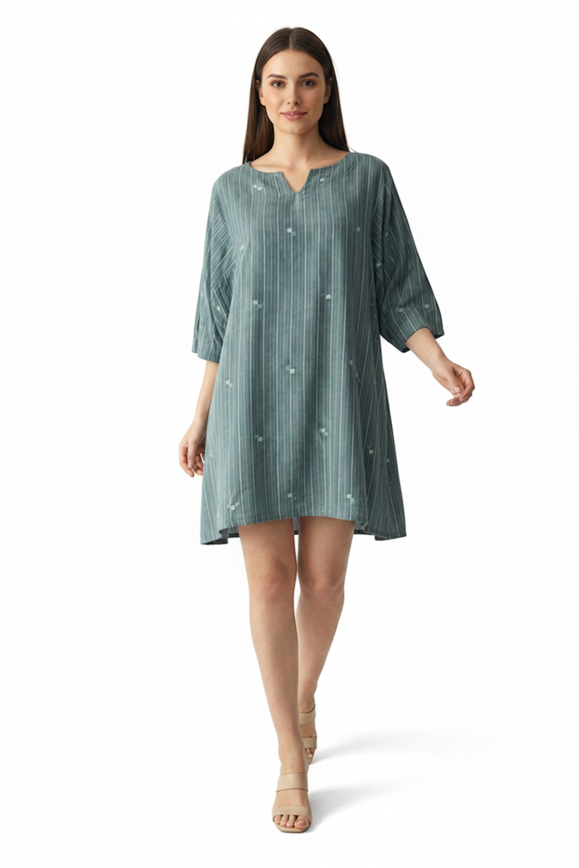 Woman wearing a green dress with white stripes and patterns in jamdani