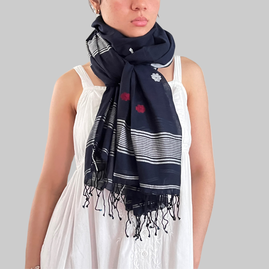 Woman wearing a black muslin scarf with white and red floral Jamdani patterns 